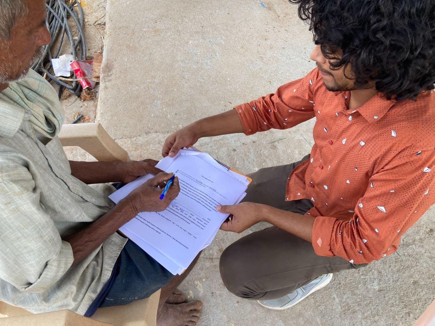A HasiruAqua field officer helps a farmer complete the subsidy paperwork on-site